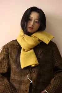 Close-up of vibrant yellow wool blend knit scarf with rich woven texture and warmth