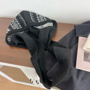 Close-up of Fair Isle snowflake pattern on black knitted Balaclava winter hat