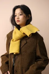Detail of yellow chunky knit scarf paired with a vintage brown plaid wool blazer coat