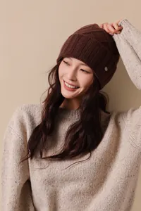 Detailed macro view of dark brown knit beanie with chunky cable wool patterns