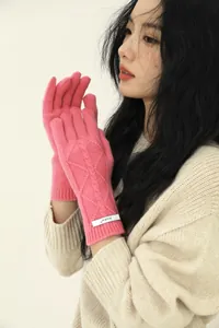 Detail view of pink merino wool cable knit gloves with elastic ribbed wrist and logo