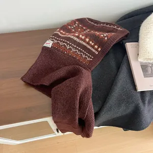 Detail of Fair Isle pattern knitwear showing thick texture and neckline logo label