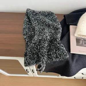 Detail van zwart-witte tweed gebreide bivakmuts met twee decoratieve zijknopen