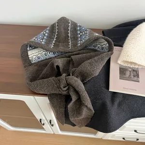 Detailed knit texture of a brown Fair Isle balaclava with warm blue and white patterns