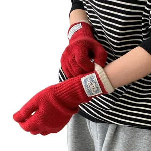 Winter red knitted gloves for women with extended wrist cuffs and stylish logo patch