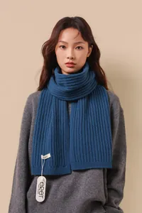 Dettaglio di sciarpa in maglia blu scuro 100% lana con trama e etichetta di qualità