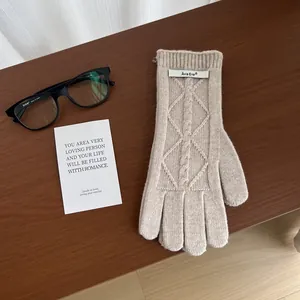 Detailed knit texture and classic cable stitch pattern on beige merino wool gloves