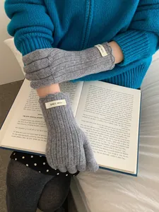 Detail of gray wool knit gloves with touch screen design and minimalist woven label