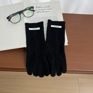 Close-up of black cable knit merino wool gloves on a vintage book and glasses