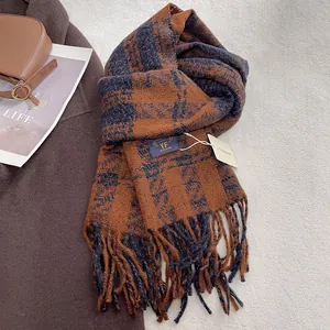 Detail of classic checkered tassel scarf in brown and navy on a stylish wool coat