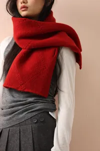 Close-up of red wool knit scarf texture worn with elegant autumn layering style