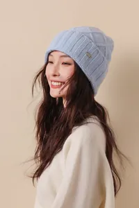 Detail of light blue Australian wool knit hat with diamond pattern and metal logo