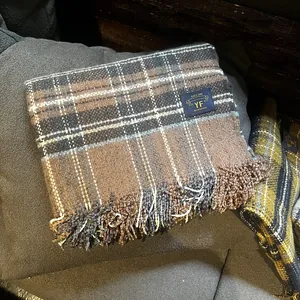 Détail de la texture de l'écharpe à carreaux avec étiquette tissée et franges douces