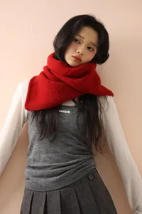 Detail shot of the chunky red knitted wool scarf texture paired with a winter outfit