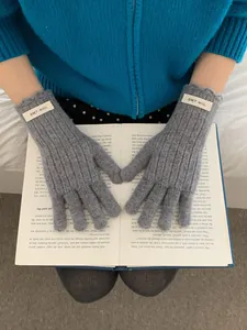 Detailed ribbed texture of grey wool touch-screen gloves with ERET WOOL label