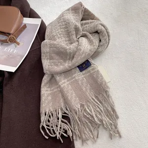 Detailed view of beige and brown plaid fringe scarf with soft cashmere texture