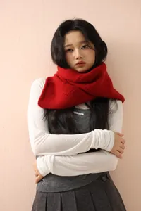 Detail of red knitted wool scarf showing fluffy texture and cozy neck wrap style