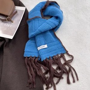 Detail of blue and brown knit scarf with fringe and vintage woven texture design