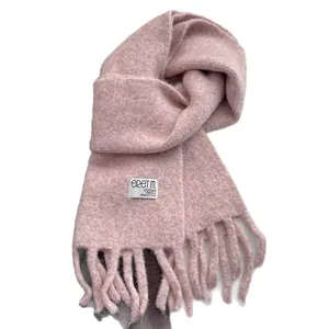 Pink wool scarf with thick fringe tassels and white woven label on white background