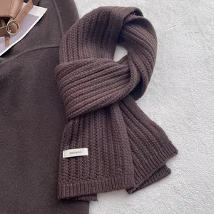 Dettaglio ravvicinato della spessa sciarpa in maglia 100% lana color marrone caffè