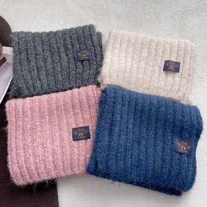 Thick knitted winter scarves set in four pastel colors with ribbed texture and woven labels