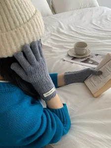 Cozy grey wool gloves with touch screen design worn during winter reading sessions