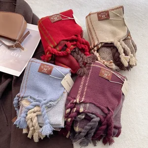 Detail of thick plaid scarves with braided tassels and leather patches for winter styling