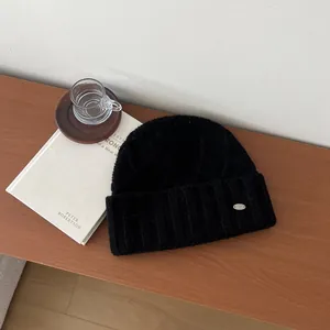 Close-up of black 100% Australian wool knit hat with stylish silver metal brand plate
