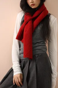 Close-up of thick red wool knit scarf with chunky cable stitch texture and cozy design