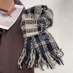 Macro shot of black and beige plaid scarf texture with brand label and fringe detail