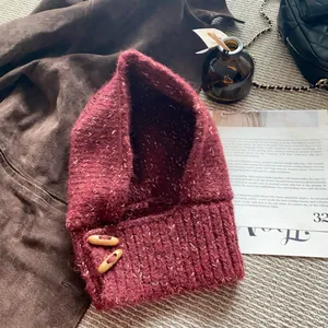 Détail de la cagoule en maille bordeaux avec boutons en corne et texture rétro