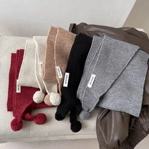 Knitted scarf with pom-pom detail in multiple colors like burgundy and oatmeal