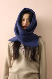 Close-up of a deep blue wool-blend balaclava featuring soft knit texture and wood buttons