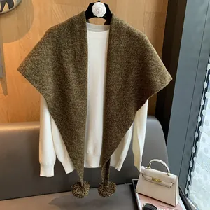 Chal triangular de lana marrón oscuro grueso con pompones decorativos y textura fina