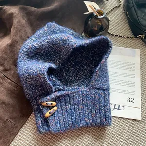 Détail de la maille chinée bleue avec boutons en corne en bois sur la cagoule