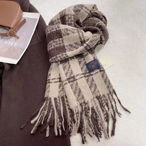 Macro shot of brown and beige plaid scarf texture with brand label and long tassels