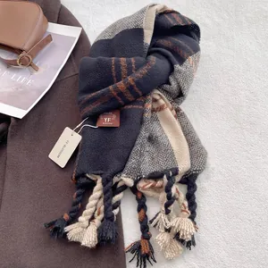 Detailed view of thick plaid tassel scarf with premium knit texture and decorative leather tag