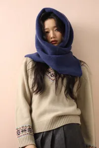 Detail of navy blue knitted wool hooded scarf featuring warm neck protection and thick texture