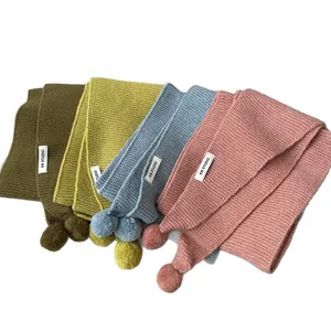 Chic knitted scarves with plush pom-poms in vibrant colors for winter warmth