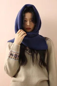 Detail of dark blue knit balaclava scarf paired with a beige Nordic sweater