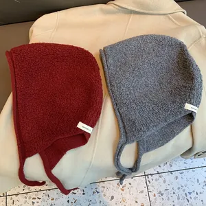Détail de cagoules en laine 100% rouge et grise avec texture et protège-oreilles