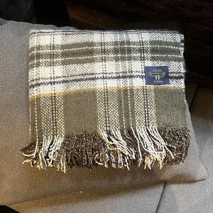 Détail de la texture d'une écharpe à carreaux avec étiquette et franges classiques