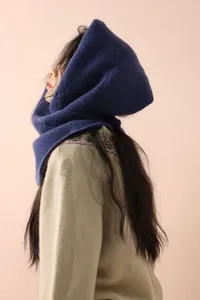 Detail of navy blue knitted hooded wool scarf with plush texture for winter warmth