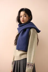Detailed view of dark blue wool knit scarf with diamond hollow pattern and soft texture