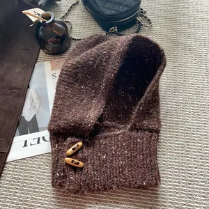 Détail d'une cagoule en maille marron foncé avec boutons en corne et style rétro