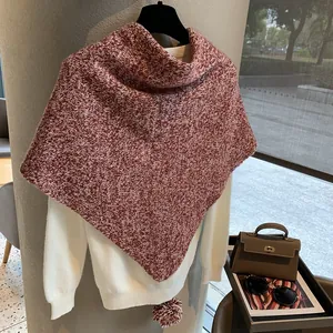 Detailed texture of red and white knit wool shawl featuring a soft pom-pom decorative tassel