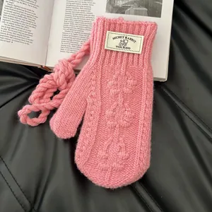 Détail de la moufle tricotée rose avec vue macro de la laine texturée et de l'étiquette