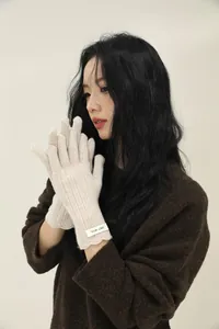 Detail of wool knit glove with scalloped cuff and ribbed texture in cream white