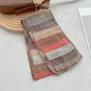 Minimalist pure linen striped scarf in earth tones of brown and beige on wooden tray