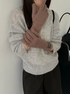 Detailed texture of mocha brown knitted wool gloves with minimalist wrist patch decoration